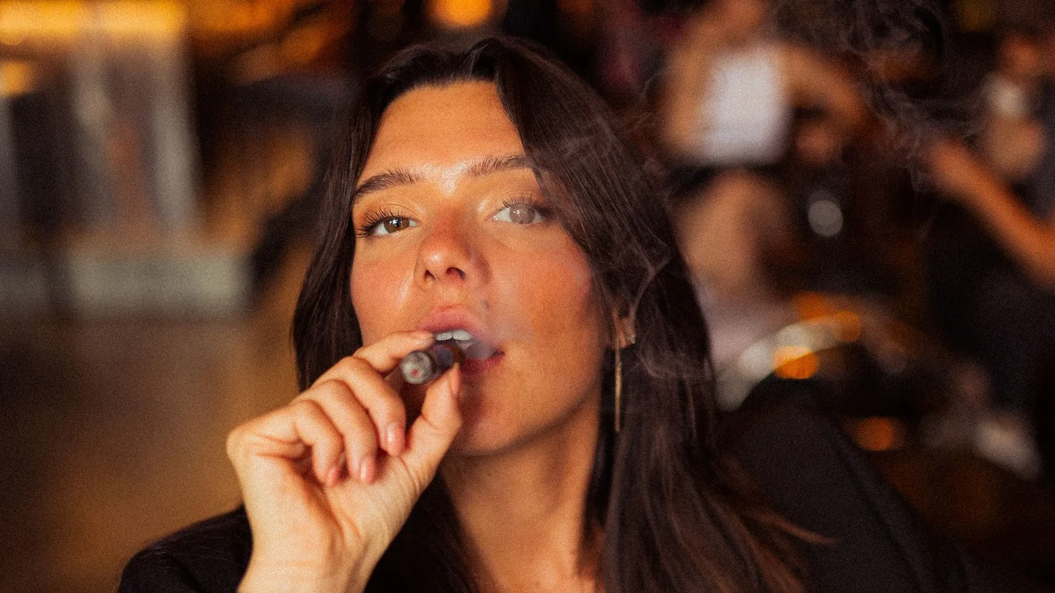 A guest smoking a Corona at a bar